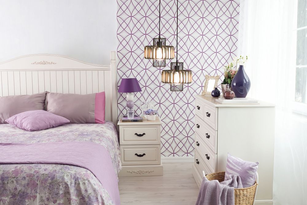 chambre à coucher de couleur lavande avec un lit, une table de chevet et une commode