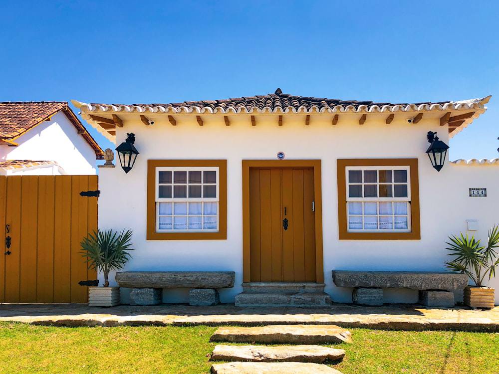 Modelo de casa pequena com dois quartos e portão de madeira