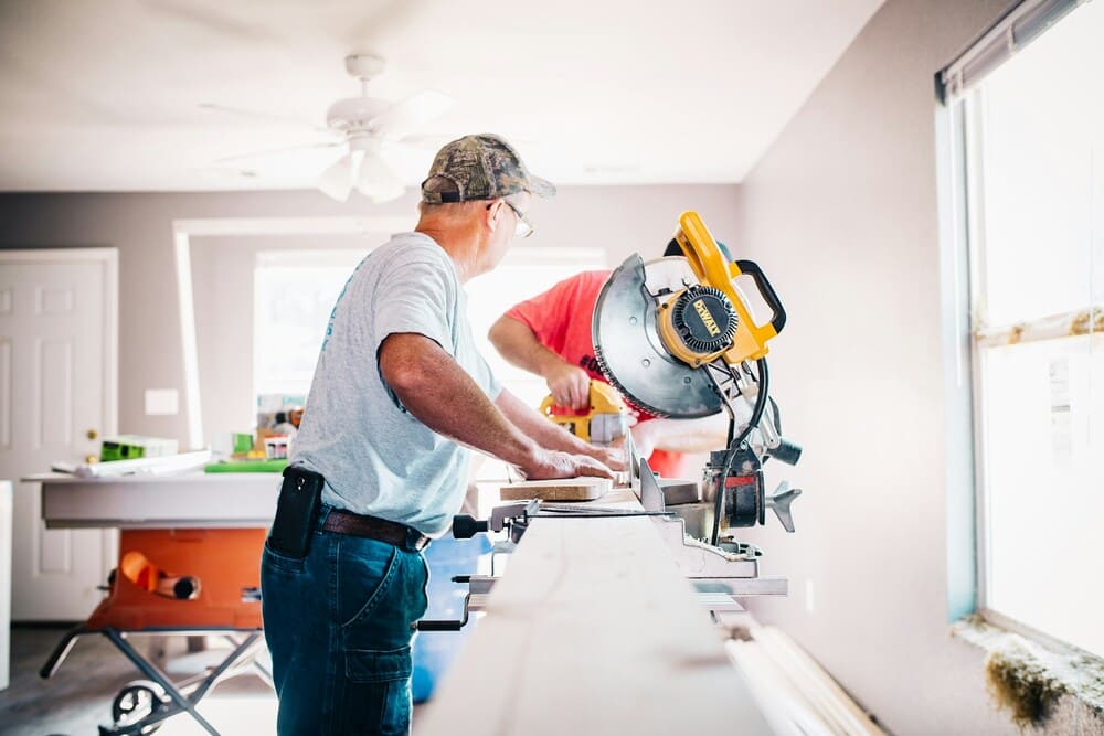 obra em andamento: dois homens construindo móveis de madeira para casa